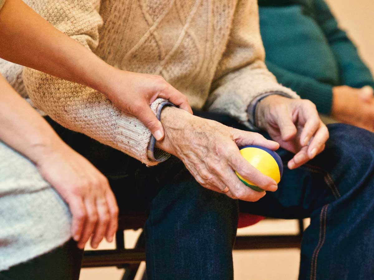 woman holding elderly man's wrist