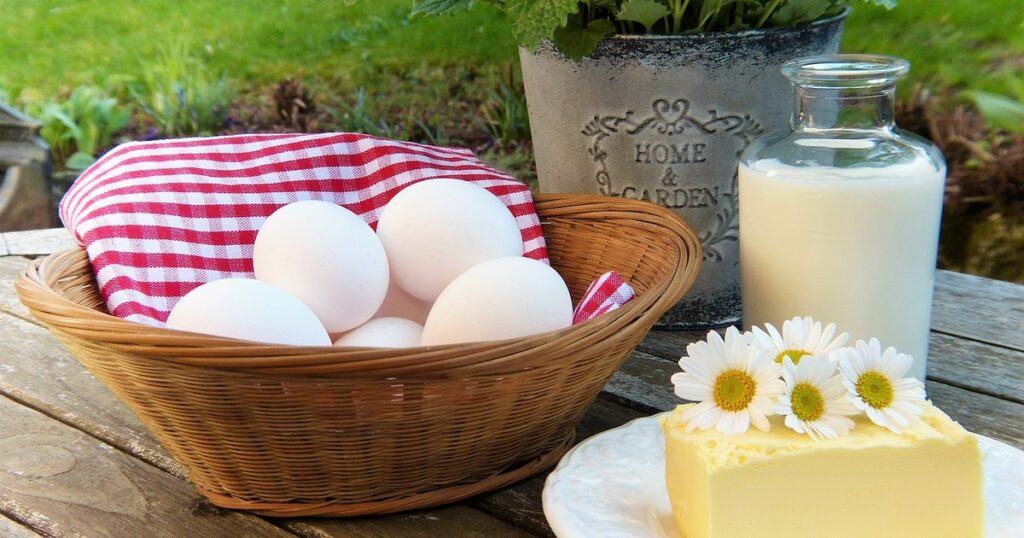 Basket of eggs, plate of butter and glass flask of milk representing calcium