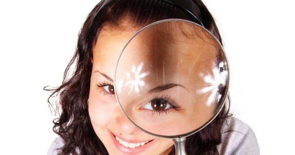 girl with eye magnifier showing good eye health